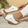 White wedge slide sandals with open toe and stitched upper on thick platform