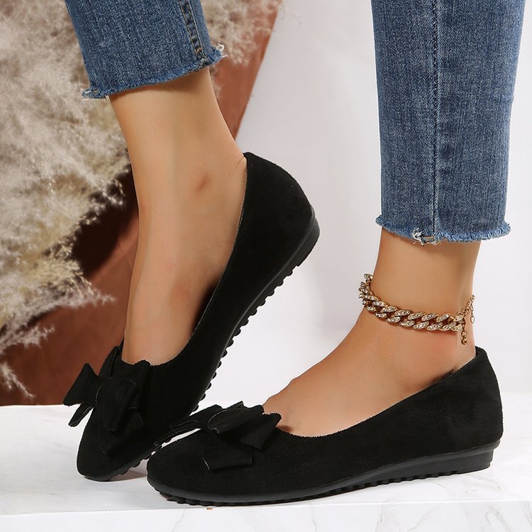 Black suede bow comfort loafers with low profile and textured rubber sole