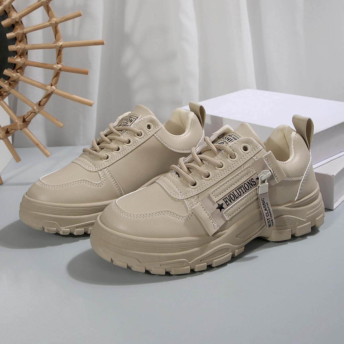 Cream lace-up chunky-sole sneakers with side logo strap on display