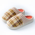 Plaid plush indoor slippers with ribbed cream trim; yellow plaid uppers and red lining.