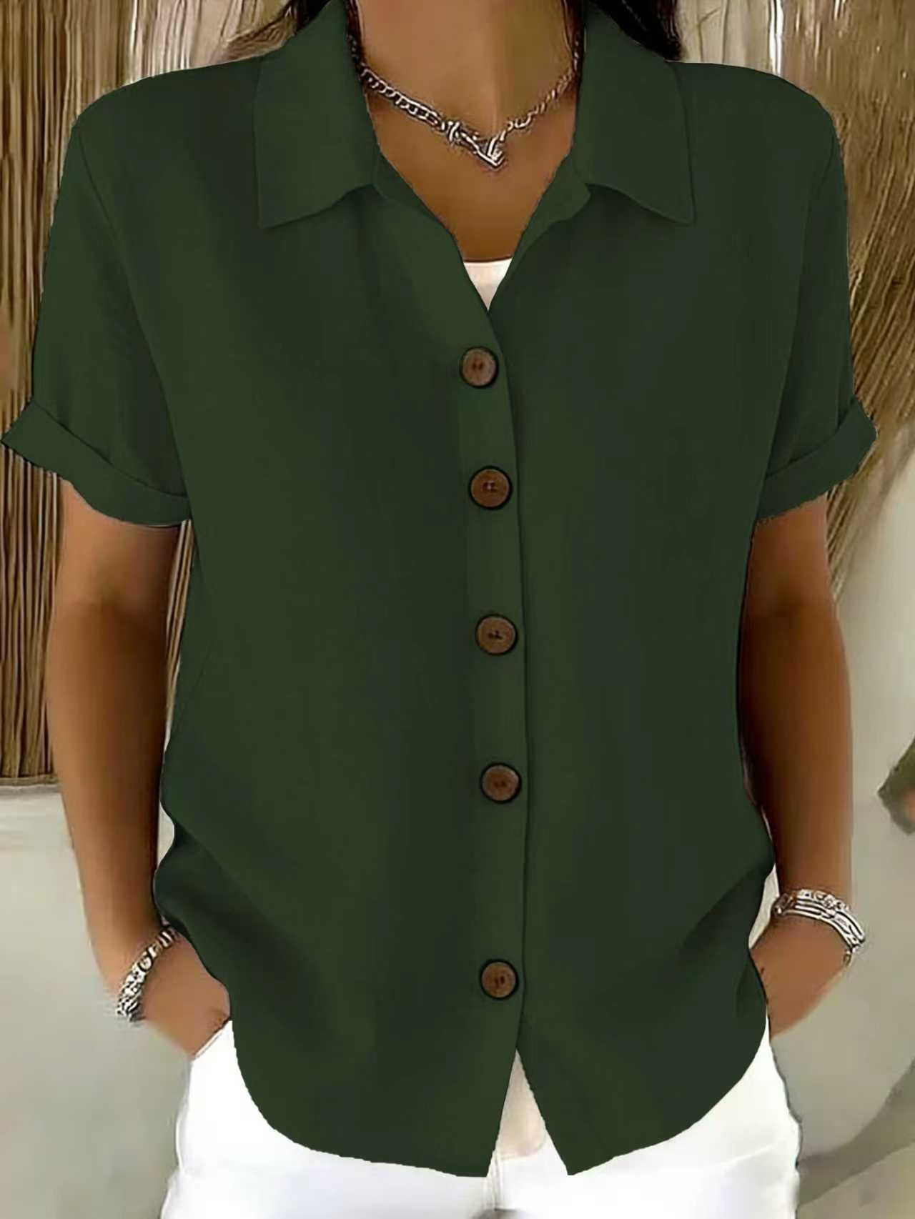 Women's collared button-front shirt in dark green with short sleeves and dark buttons.