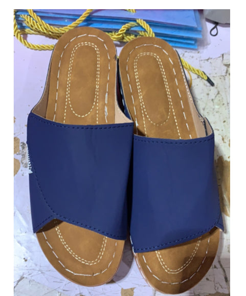 Blue wedge slide sandals set with open toe and tan stitched footbed