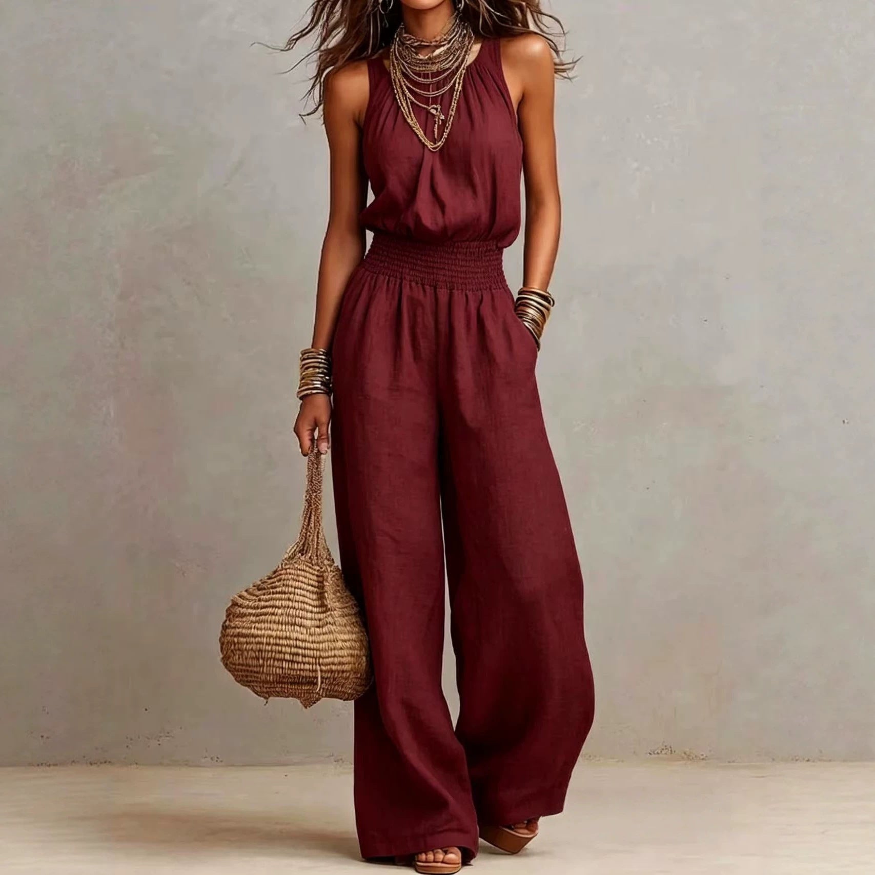 Wine red sleeveless jumpsuit with halter neck, smocked waist, and wide legs