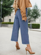 Blue high-waist wide-leg jeans with frayed cuffs and wide straight legs.