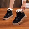 Pair of black lace-up ankle snow boots with sherpa trim and chunky tread sole