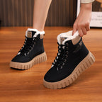 Pair of black lace-up ankle snow boots with sherpa trim and chunky tread sole
