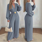 Slate blue deep V-neck slim-fit jumpsuit with long sleeves and round gold belt