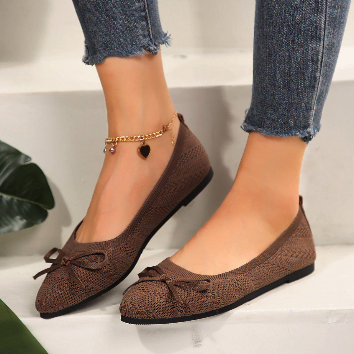 Brown knit pointed-toe loafers with bow and gold beaded ankle chain