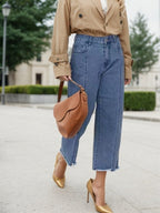 Blue high-waist wide-leg jeans with belt loops, front seams, and frayed hem.