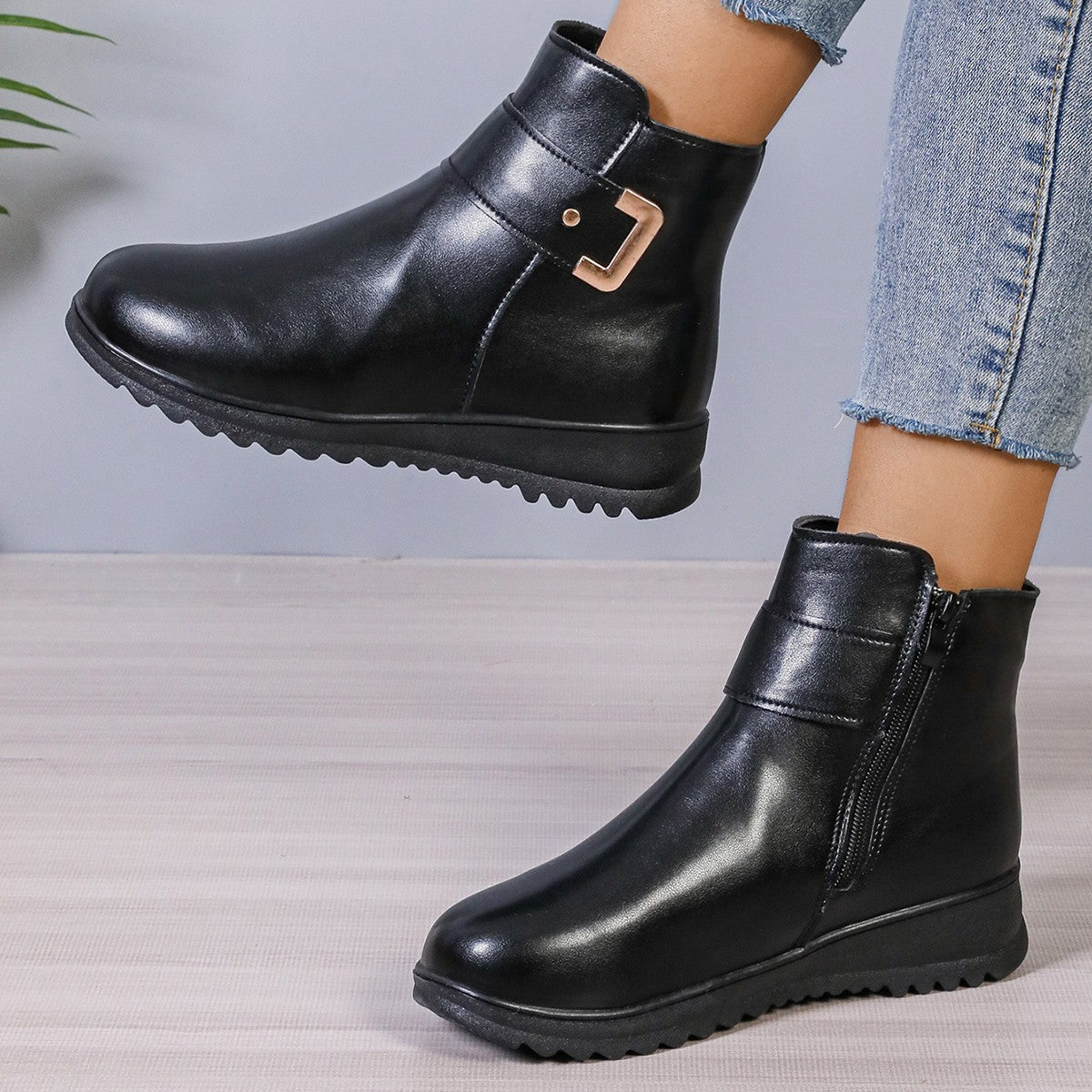 Women’s black ankle boots with buckle strap detail and chunky rubber sole