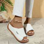 White wedge slide sandals with open toe and stitched strap detail on brown sole