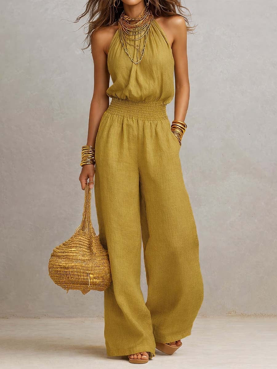 Yellow sleeveless jumpsuit with halter neck, smocked waist, and wide legs