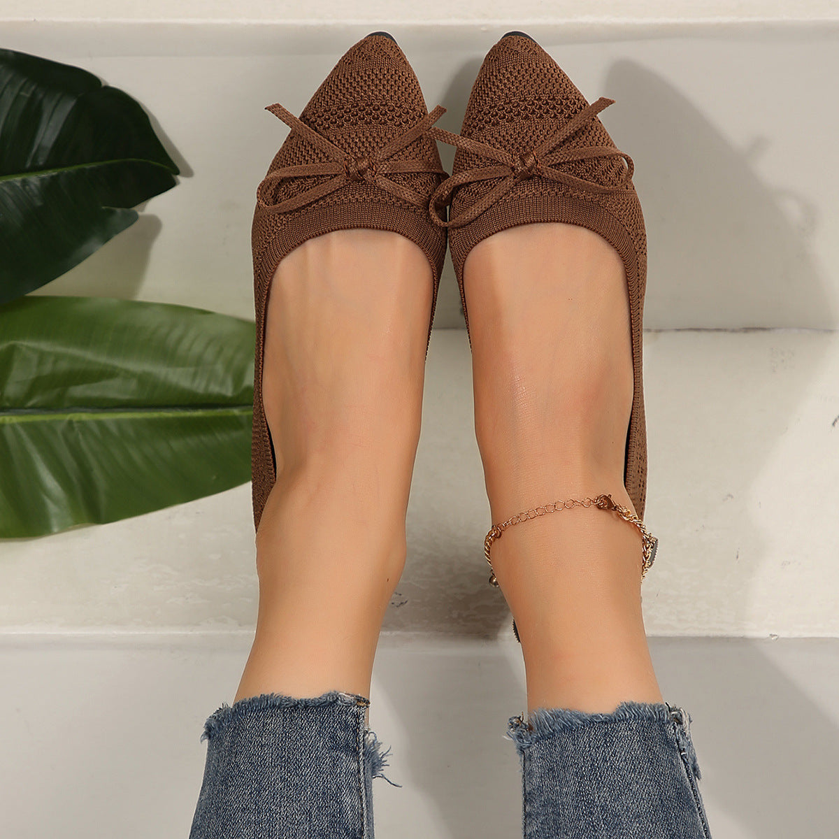 Brown knit pointed-toe loafers with bow and gold beaded ankle chain