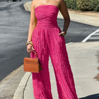Pink strapless ruched wide-leg jumpsuit with gathered bodice and flowing pants