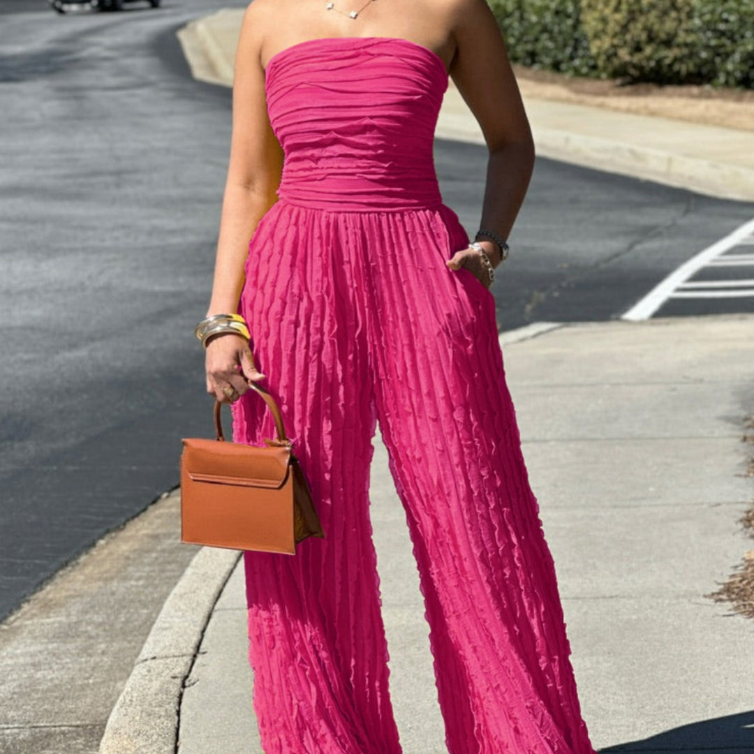 Pink strapless ruched wide-leg jumpsuit with gathered bodice and flowing pants