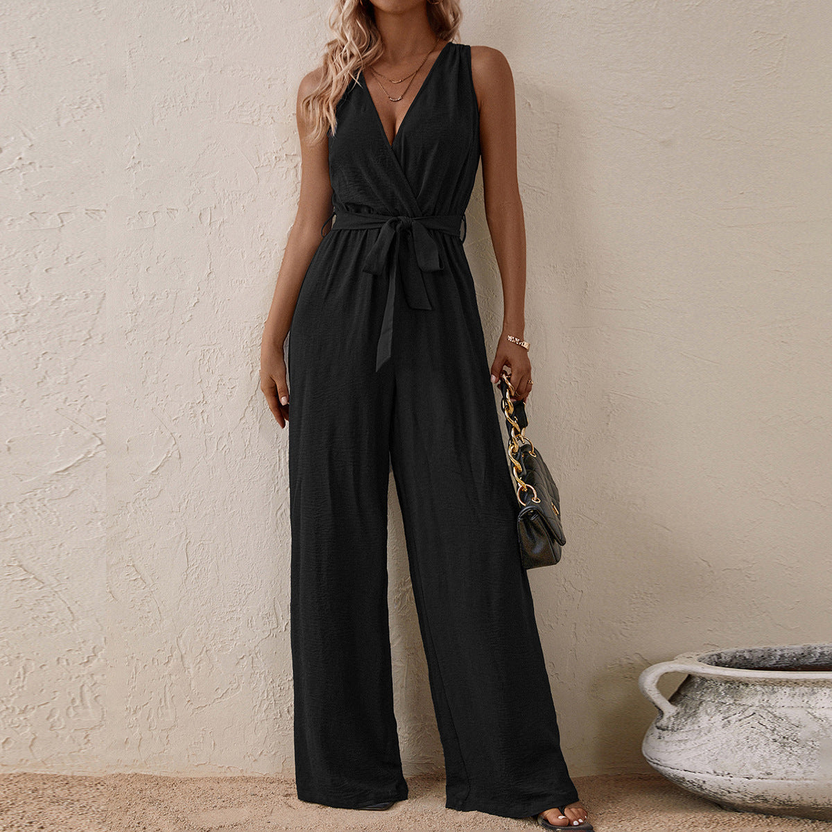 Black high-waist sleeveless jumpsuit with V-neck, tie waist, and wide legs