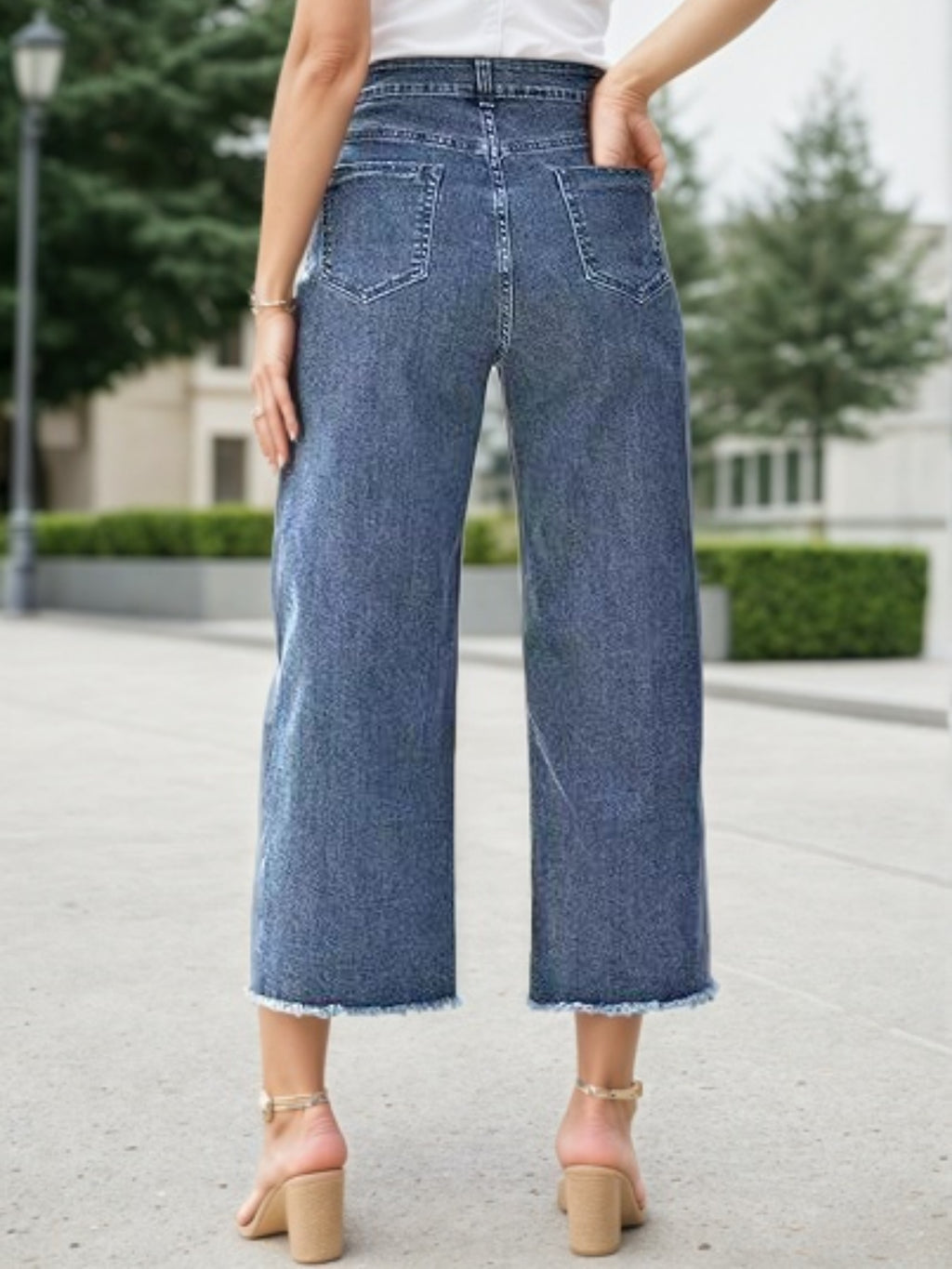 Blue high-waist wide-leg jeans with frayed bottom hem and front patch pockets.