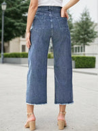 Blue high-waist wide-leg jeans with frayed bottom hem and front patch pockets.