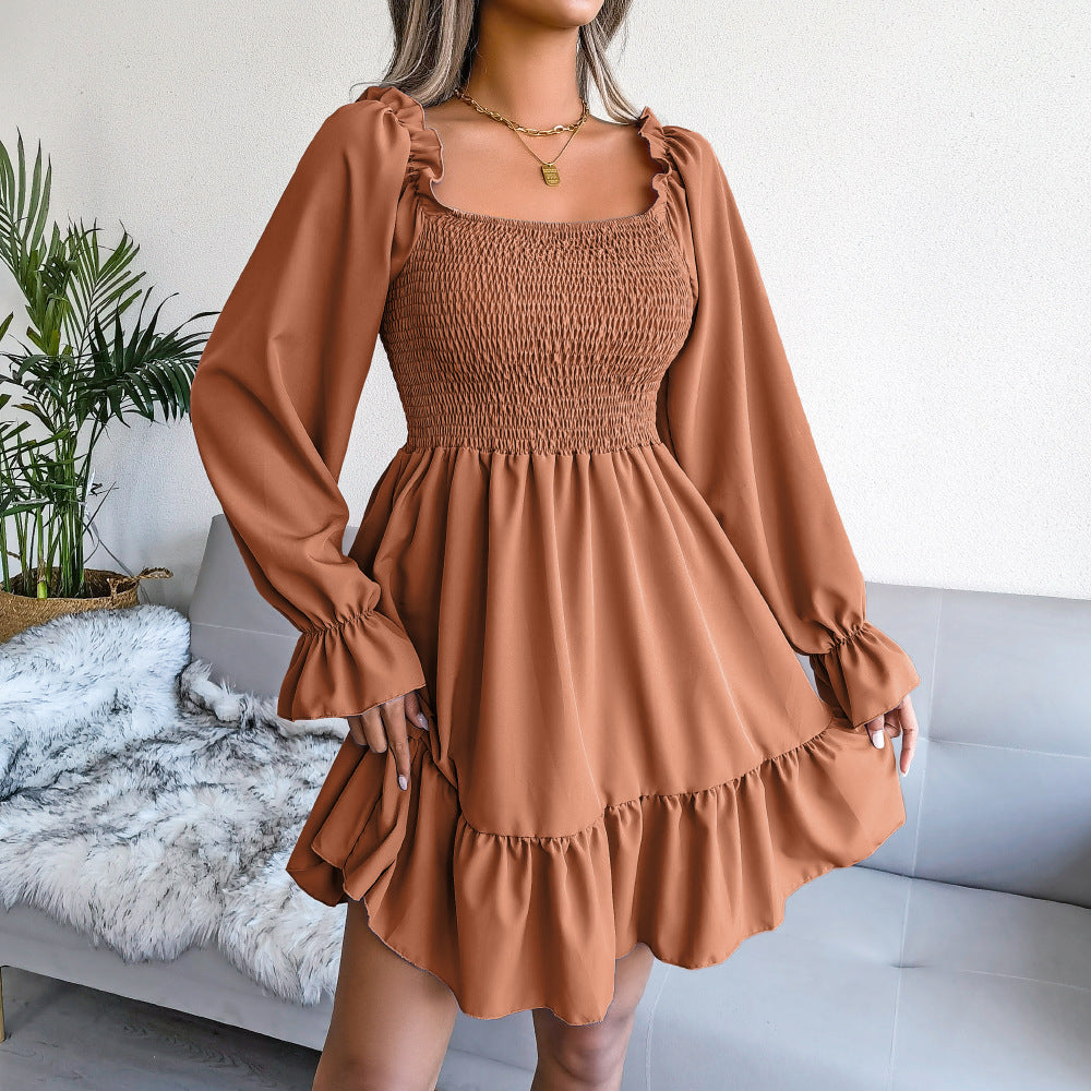 Tan square-neck ruffle swing dress with long puff sleeves and tiered ruffle hem.
