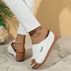 White wedge slide sandals with open toe and stitched strap detail on brown sole