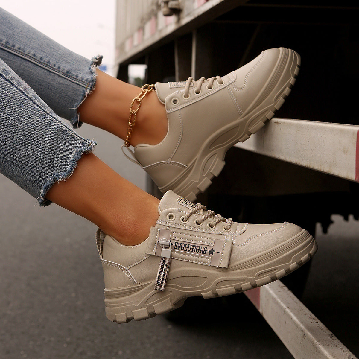 Cream lace-up chunky-sole sneakers worn with gold chain ankle bracelet
