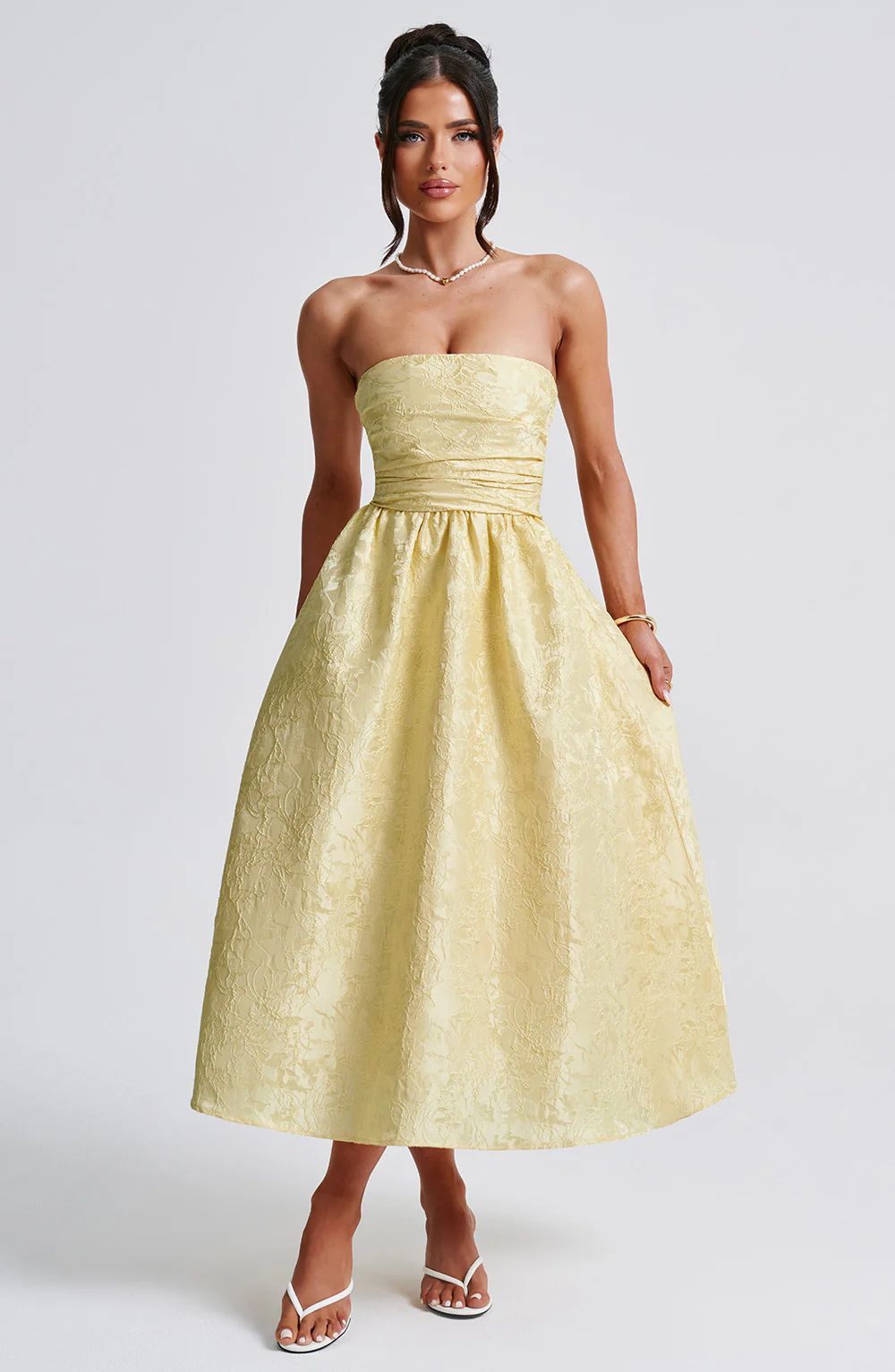 Yellow satin jacquard tube top dress with gathered waist and flared midi skirt.
