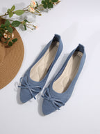 Blue knit pointed-toe loafers with front bow detail and slip-on cut
