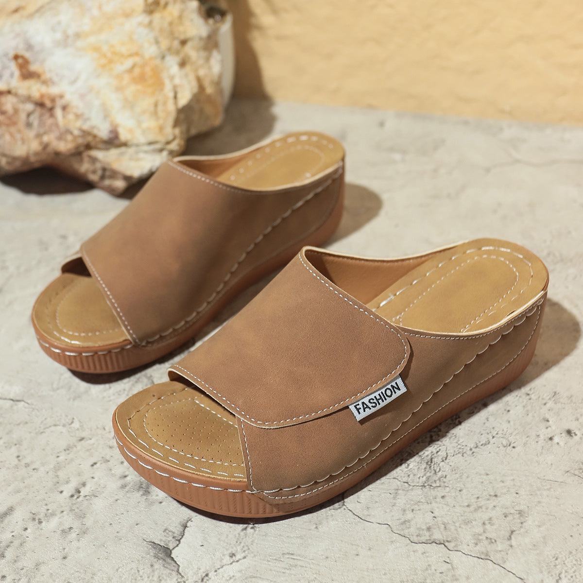 Brown wedge slide sandals with open toe and stitched upper on thick platform