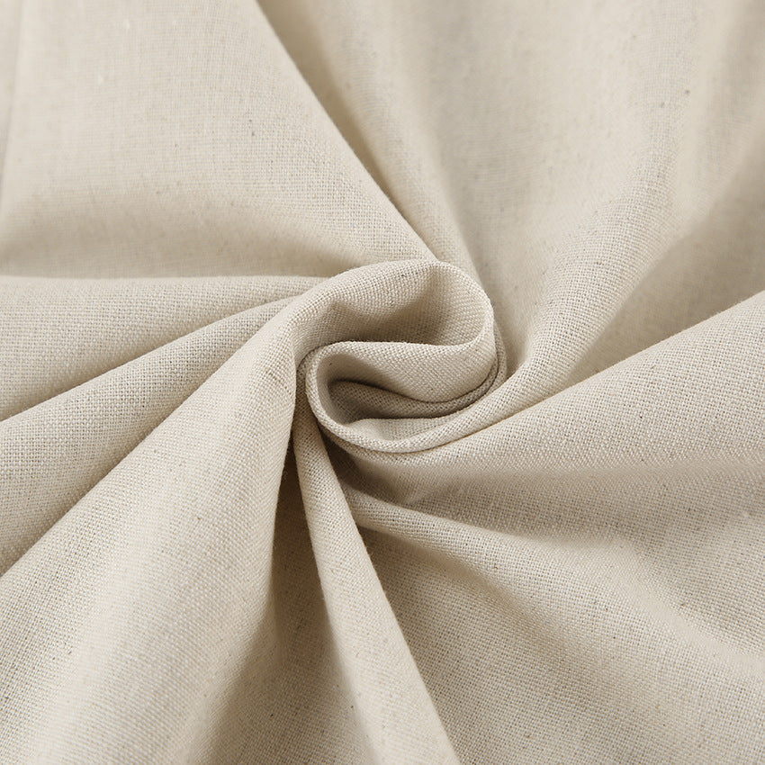 Light cream linen fabric close-up with natural woven texture and soft folds