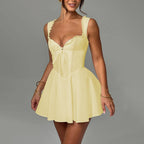 Yellow corset-style mini dress with bow front, lace trim straps, and flared skirt