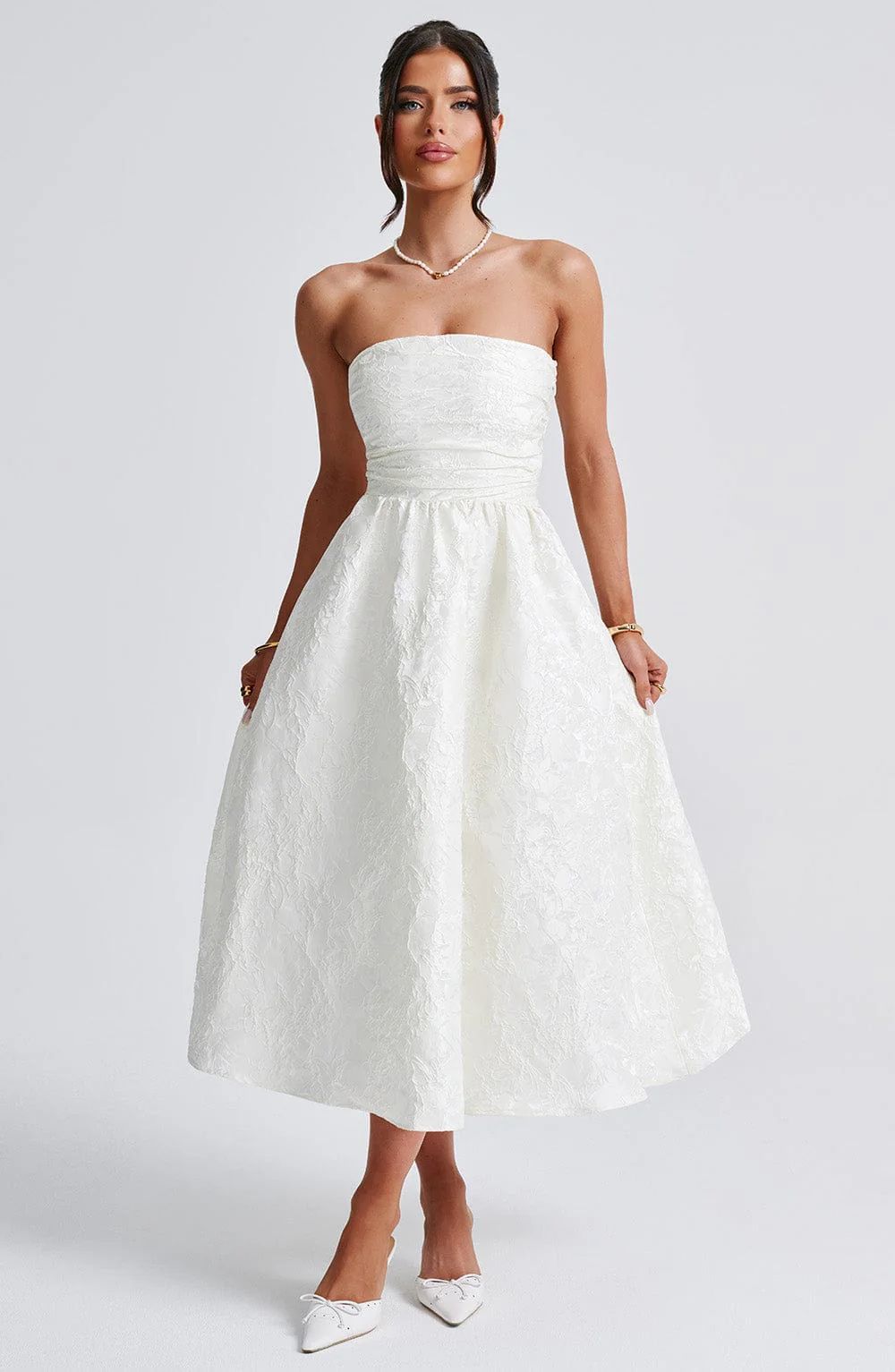 White satin jacquard tube top dress with fitted bodice and flared midi skirt.