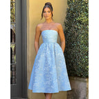 Blue satin jacquard tube top dress with gathered bodice and knee-length flared skirt.